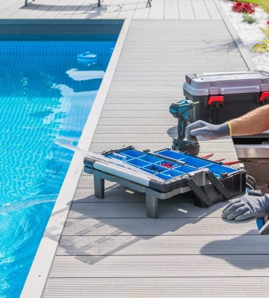 Électricien au travail sur la terrasse d'une piscine creusée